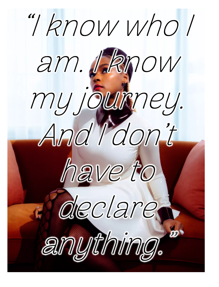 A picture of Janelle Monáe with a superimposed quote, "I know who I am. I know my journey. And I don't have to declare anything." She is wearing a futuristic white dress with a black collar and fishnet tights, sitting on an orange couch with a white background.